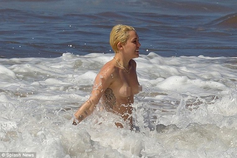 Miley Cyrus topless in the ocean with boyfriend Patrick Schwarzenegger 